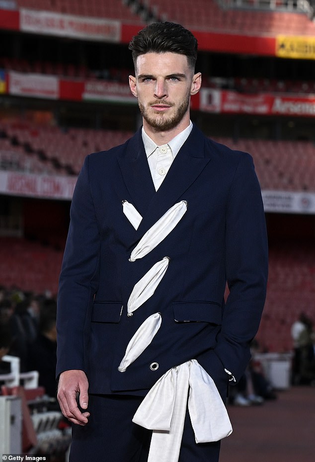 He teamed the number with a pair of matching trousers and opted for a white shirt buttoned to the top