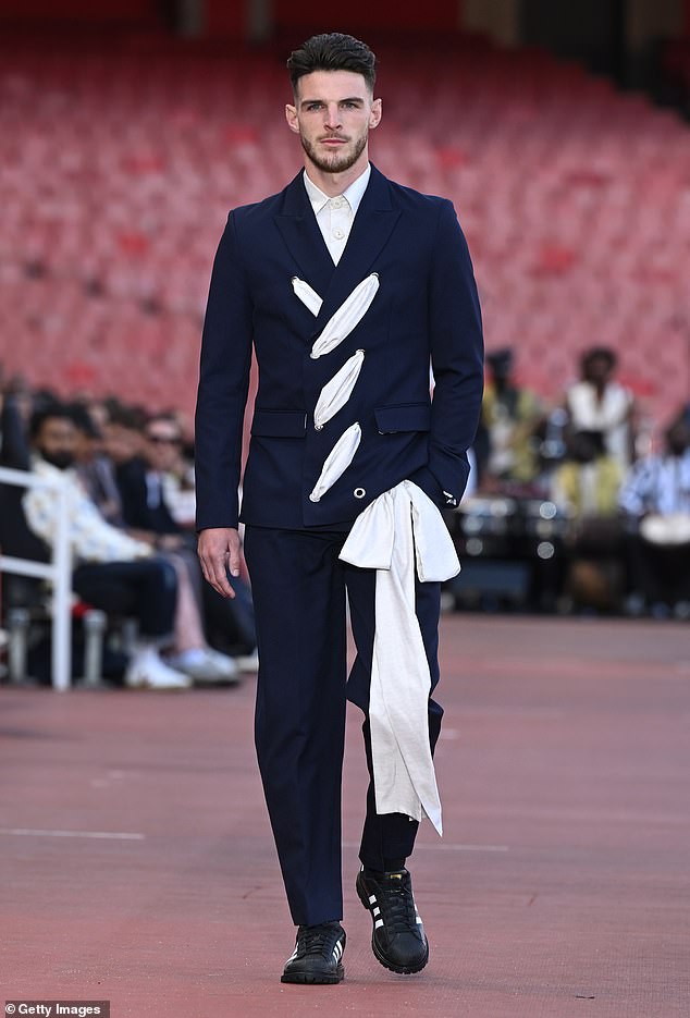 Declan Rice cut a dapper figure in a quirky navy suit as he walked the Labrum runway show during London Fashion Week at The Emirates Stadium on Monday